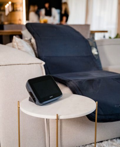 BEMER Steuergerät auf einem Beistelltisch, Anwendungsmatte auf dem Sofa